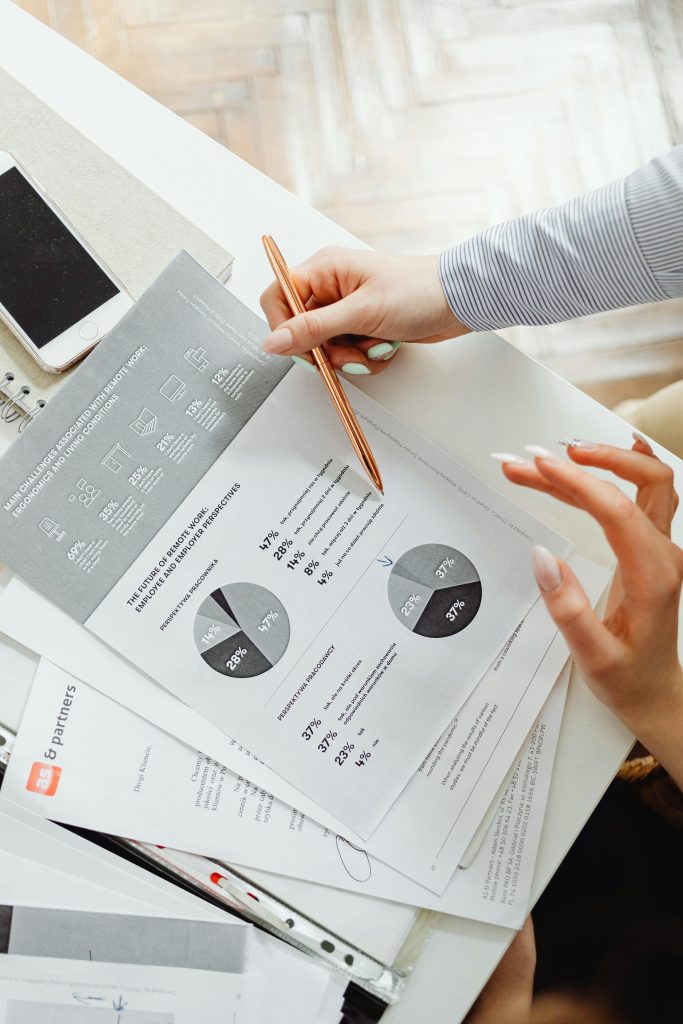 pexels-photo-7681097-7681097 Close-up of businesswoman analyzing financial reports using pie charts in an office setting.